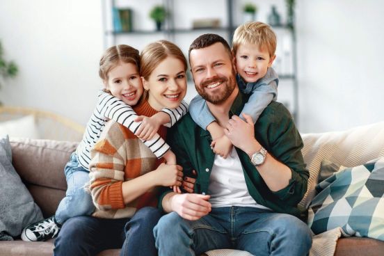 Rodzina siedząca na kanapie. Od lewej: córka, mama, tata oraz syn